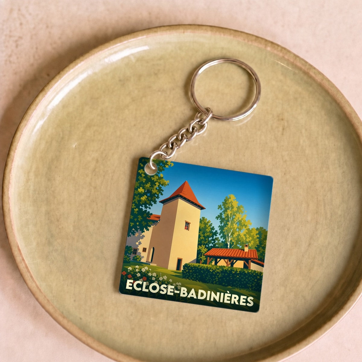 Porte-clés souvenir de la ville d'Eclose-Badinières avec une illustration stylisée.