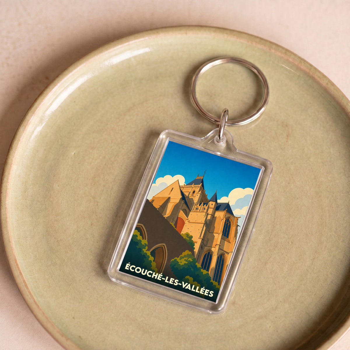 Porte-clés souvenir de la ville de Écouché-les-Vallées avec une illustration stylisée de son église.