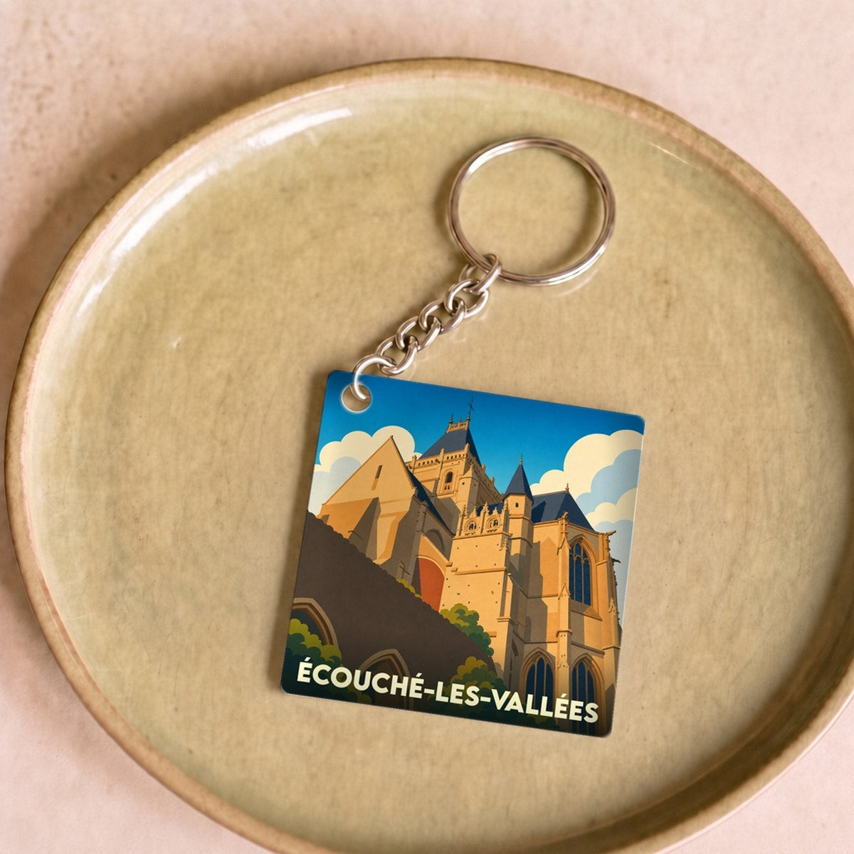 Porte-clés souvenir de la ville de Écouché-les-Vallées avec une illustration stylisée de son église.