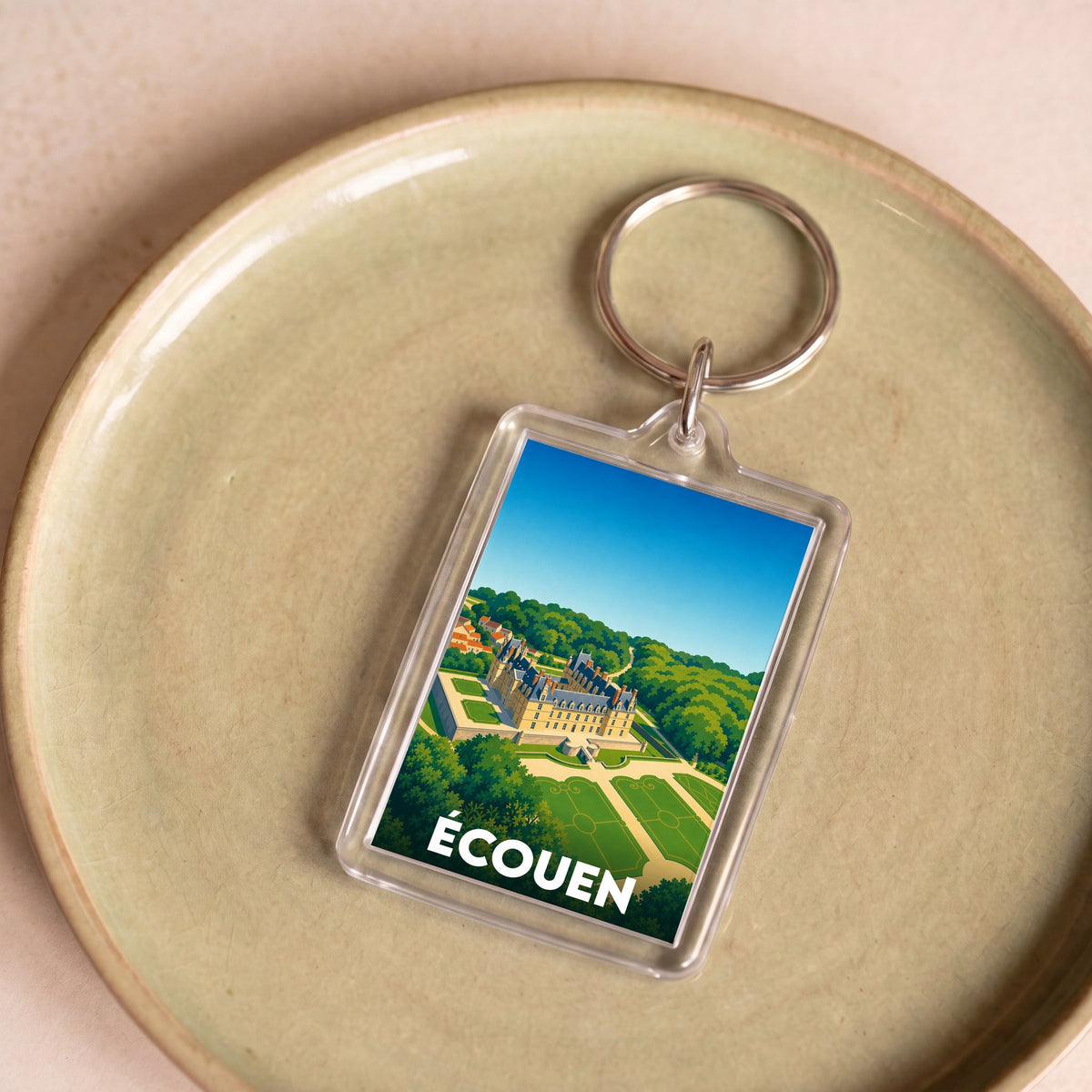 Porte-clés souvenir de la ville d'Écouen avec une illustration stylisée du château.