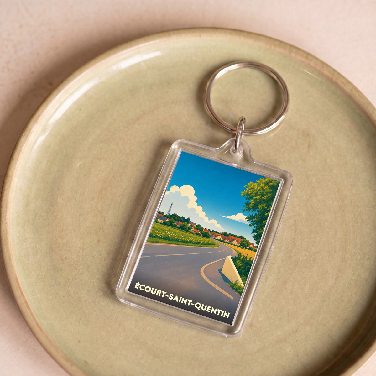 Porte-clés souvenir de la ville d'Écourt-Saint-Quentin avec une illustration stylisée d'un paysage de campagne.