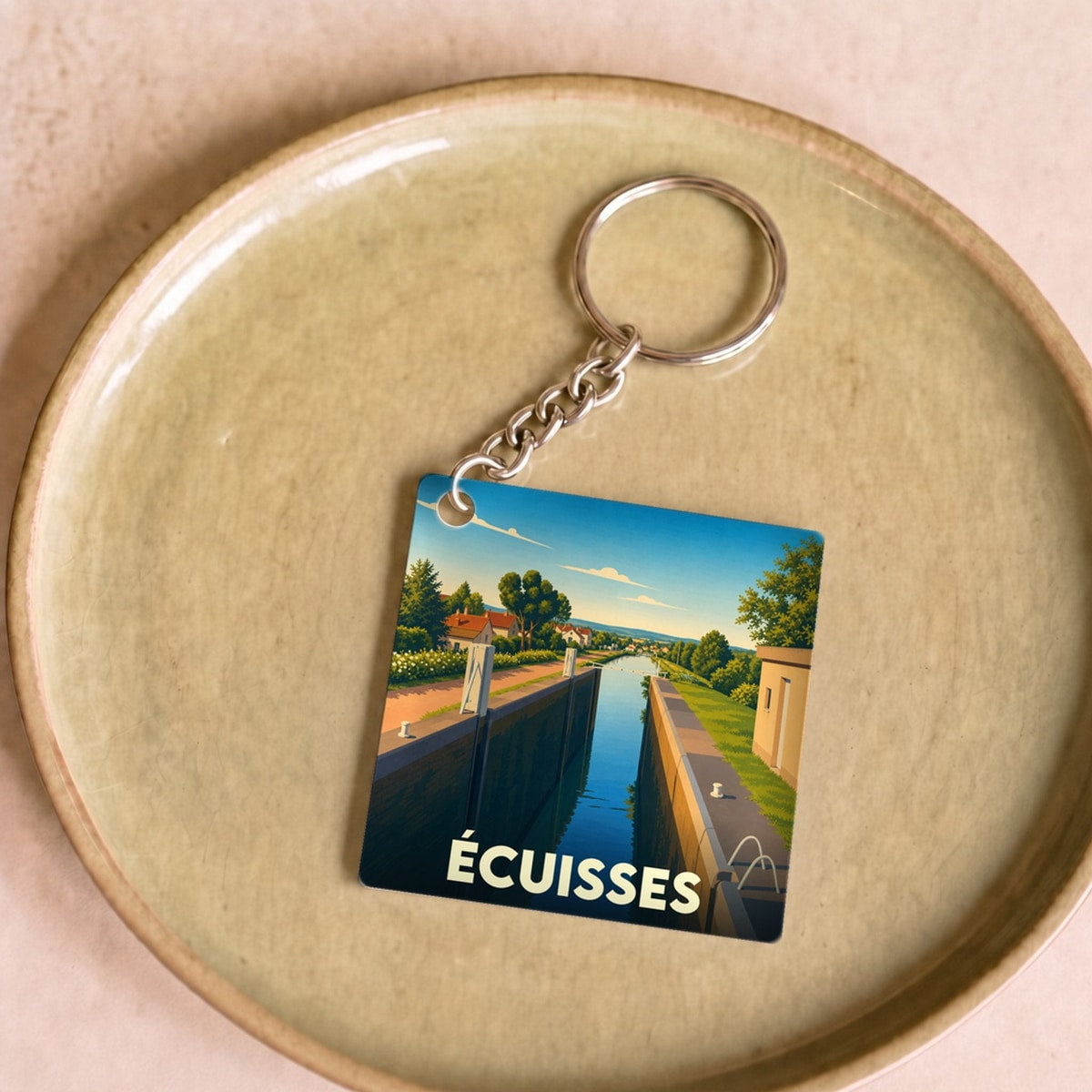 Porte-clés souvenir de la ville d'Écuisses avec une illustration stylisée de son canal.