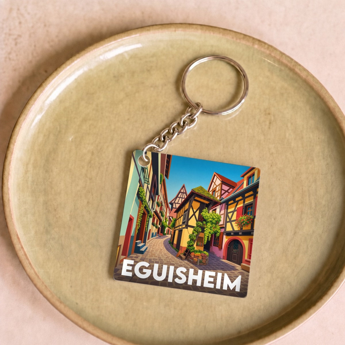 Porte-clés souvenir de la ville d'Eguisheim avec une illustration stylisée.