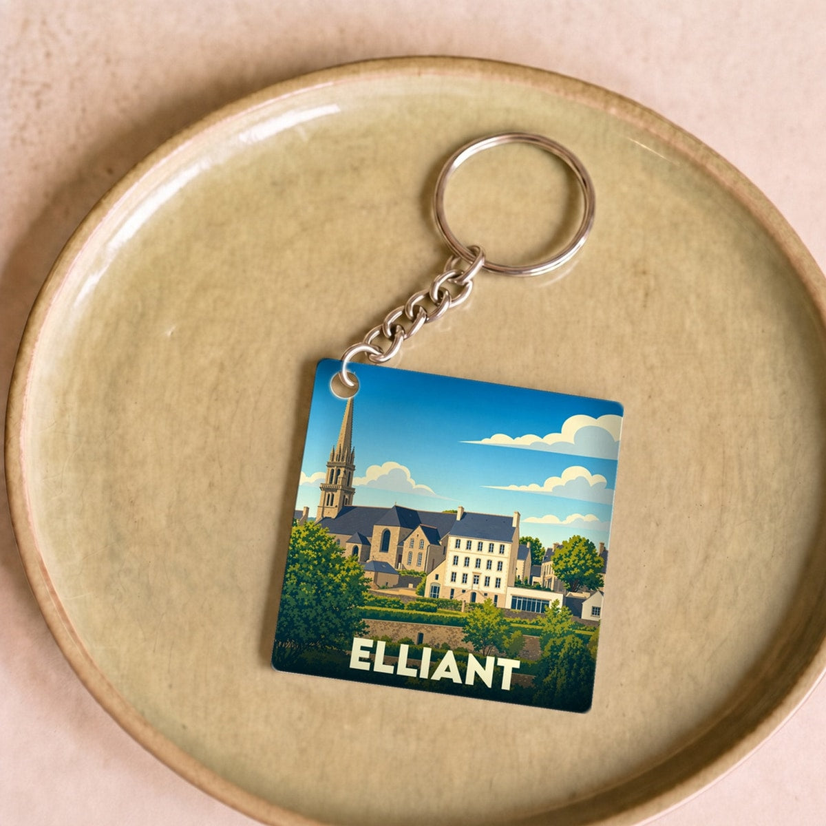 Porte-clés souvenir de la ville d'Elliant avec une illustration stylisée de son église et de ses bâtiments.