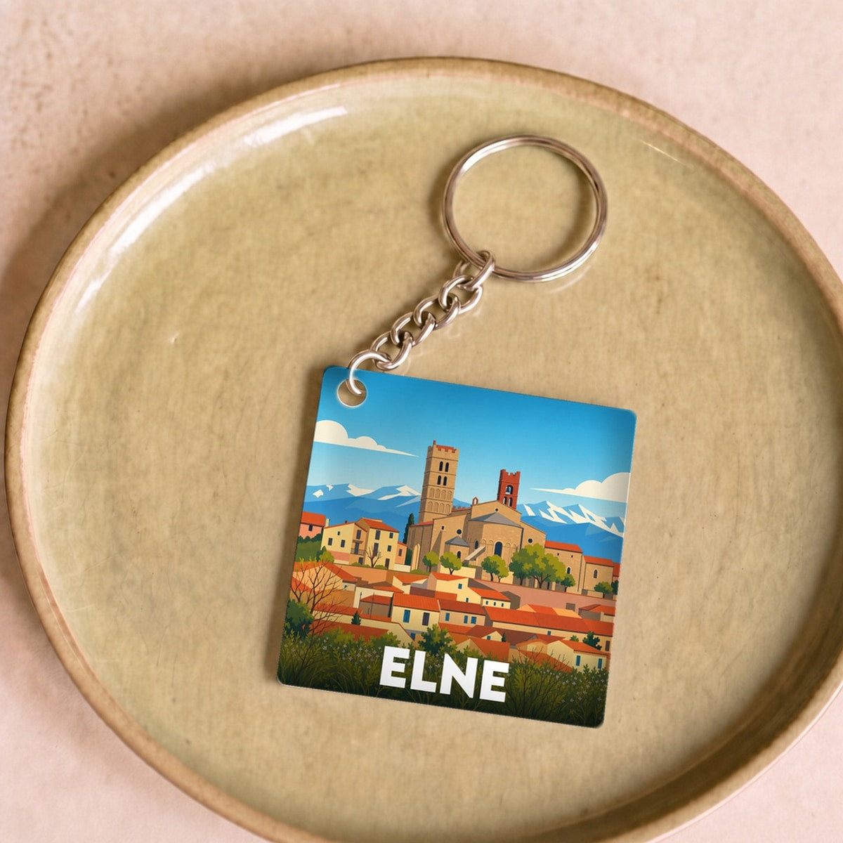 Porte-clés souvenir de la ville d'Elne avec une illustration stylisée.