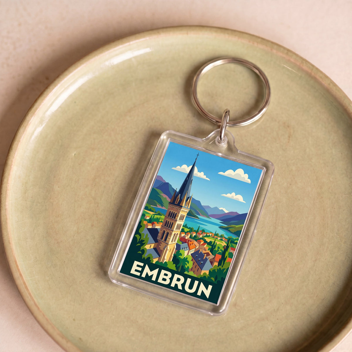 Porte-clés souvenir de la ville d'Embrun avec une illustration stylisée.