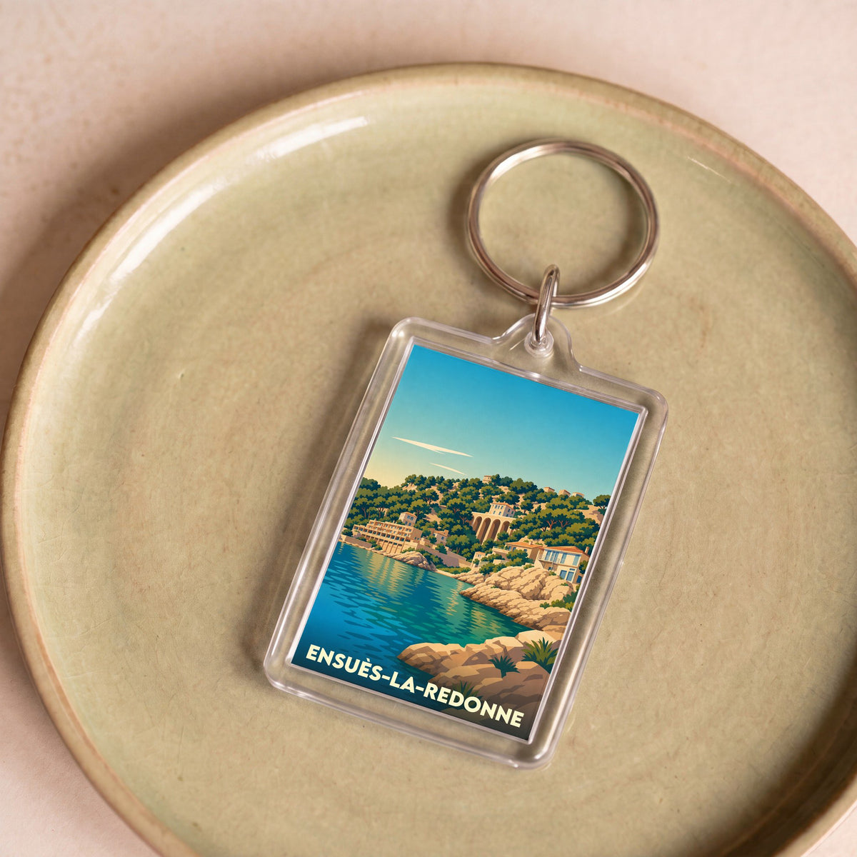 Porte-clés souvenir de la ville d'Ensuès-la-Redonne avec une illustration stylisée du bord de mer.