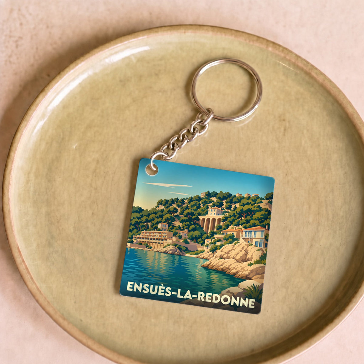Porte-clés souvenir de la ville d'Ensuès-la-Redonne avec une illustration stylisée du bord de mer.