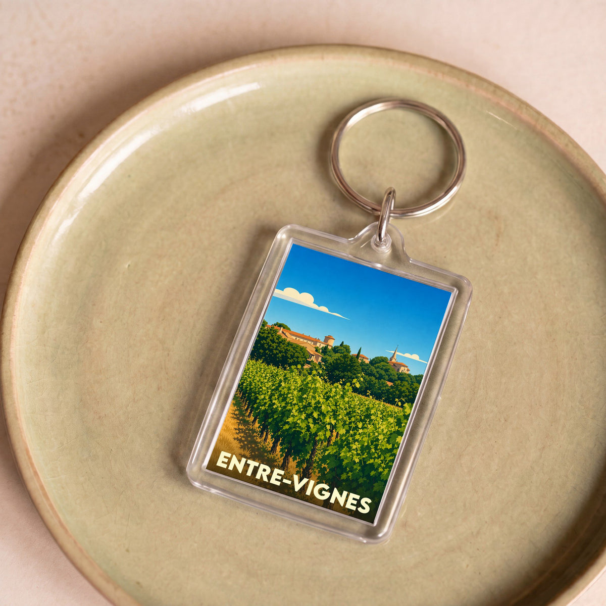 Porte-clés souvenir de la ville de Entre-Vignes avec une illustration stylisée de vignobles.