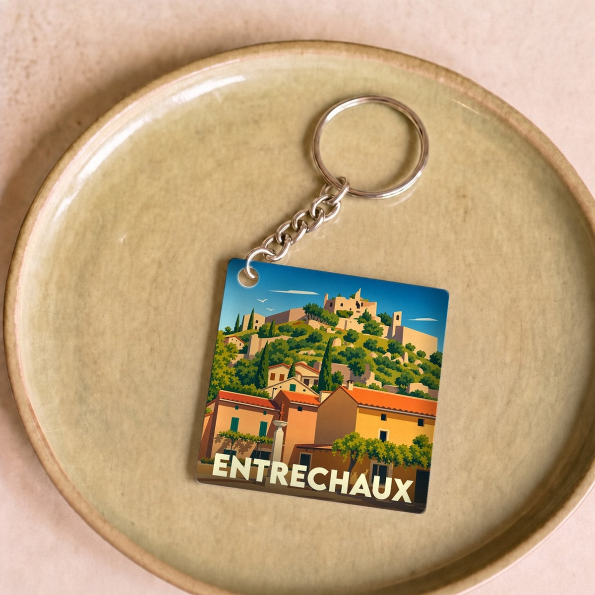 Porte-clés souvenir de la ville d'Entrechaux avec une illustration stylisée.