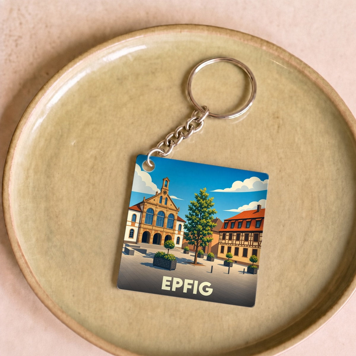 Porte-clés souvenir de la ville d'Epfig avec une illustration stylisée de sa place principale.