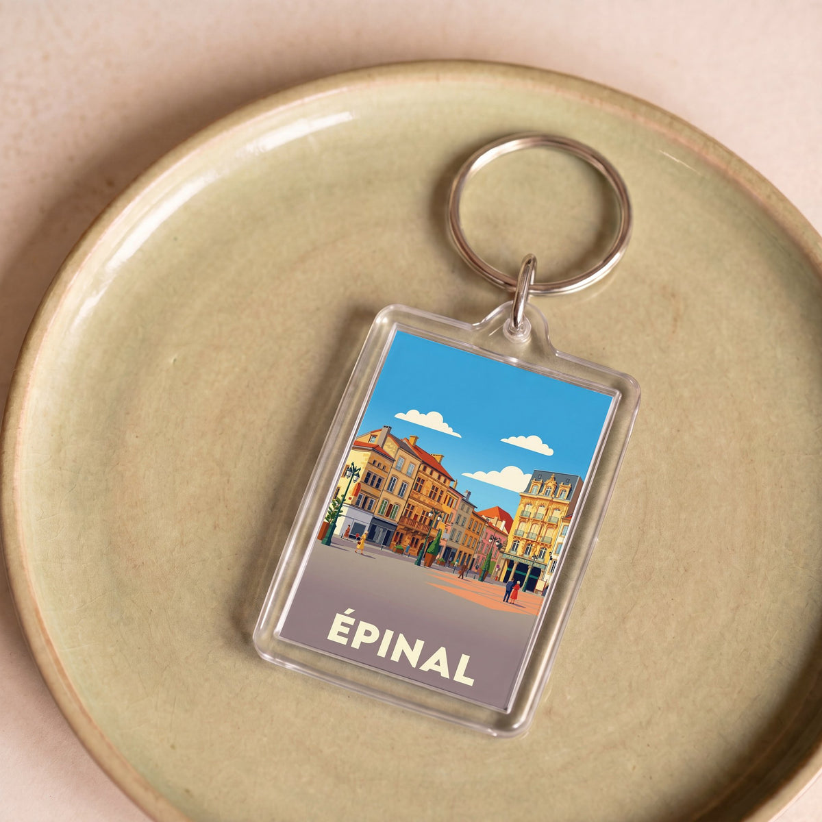 Porte-clés souvenir de la ville d'Épinal avec une illustration stylisée.