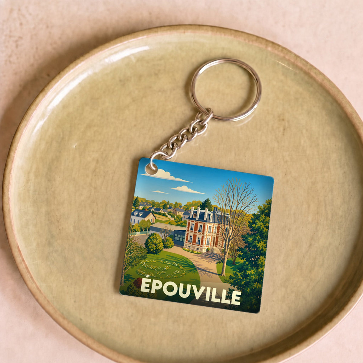 Porte-clés souvenir de la ville d'Épouville avec une illustration stylisée d'un manoir et son parc.