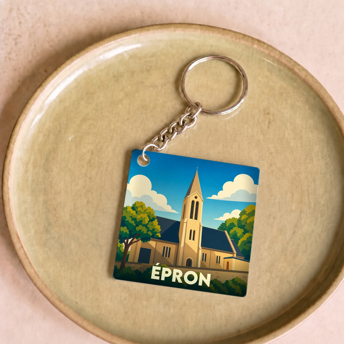 Porte-clés souvenir de la ville d'Épron avec une illustration stylisée de son église.