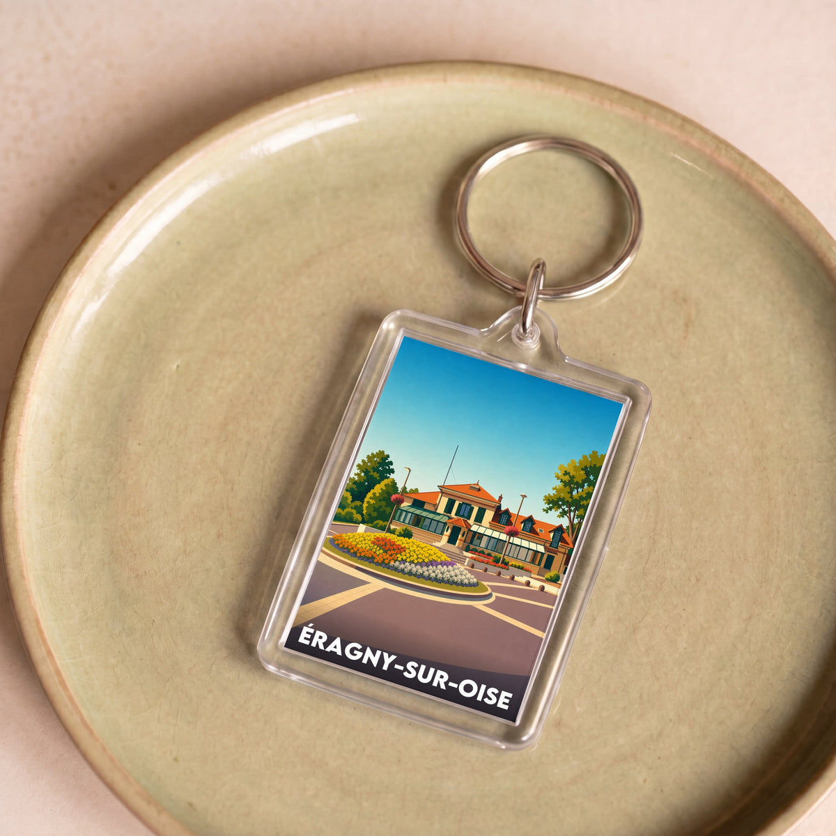Porte-clés souvenir de la ville d’Éragny-sur-Oise avec une illustration stylisée.