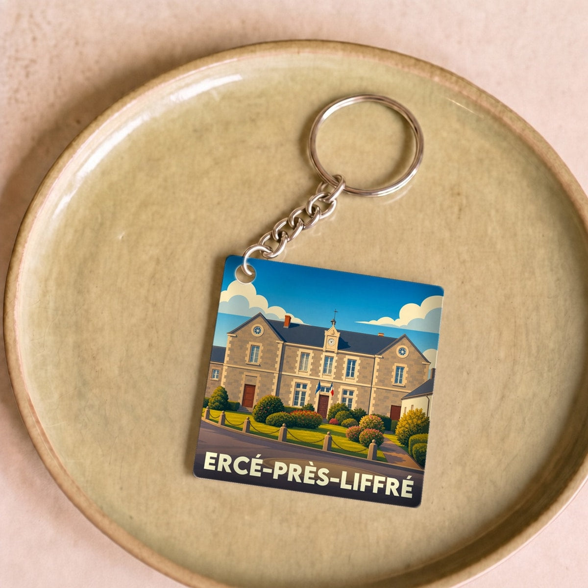 Porte-clés souvenir de la ville d'Ercé-près-Liffré avec une illustration stylisée de sa mairie.