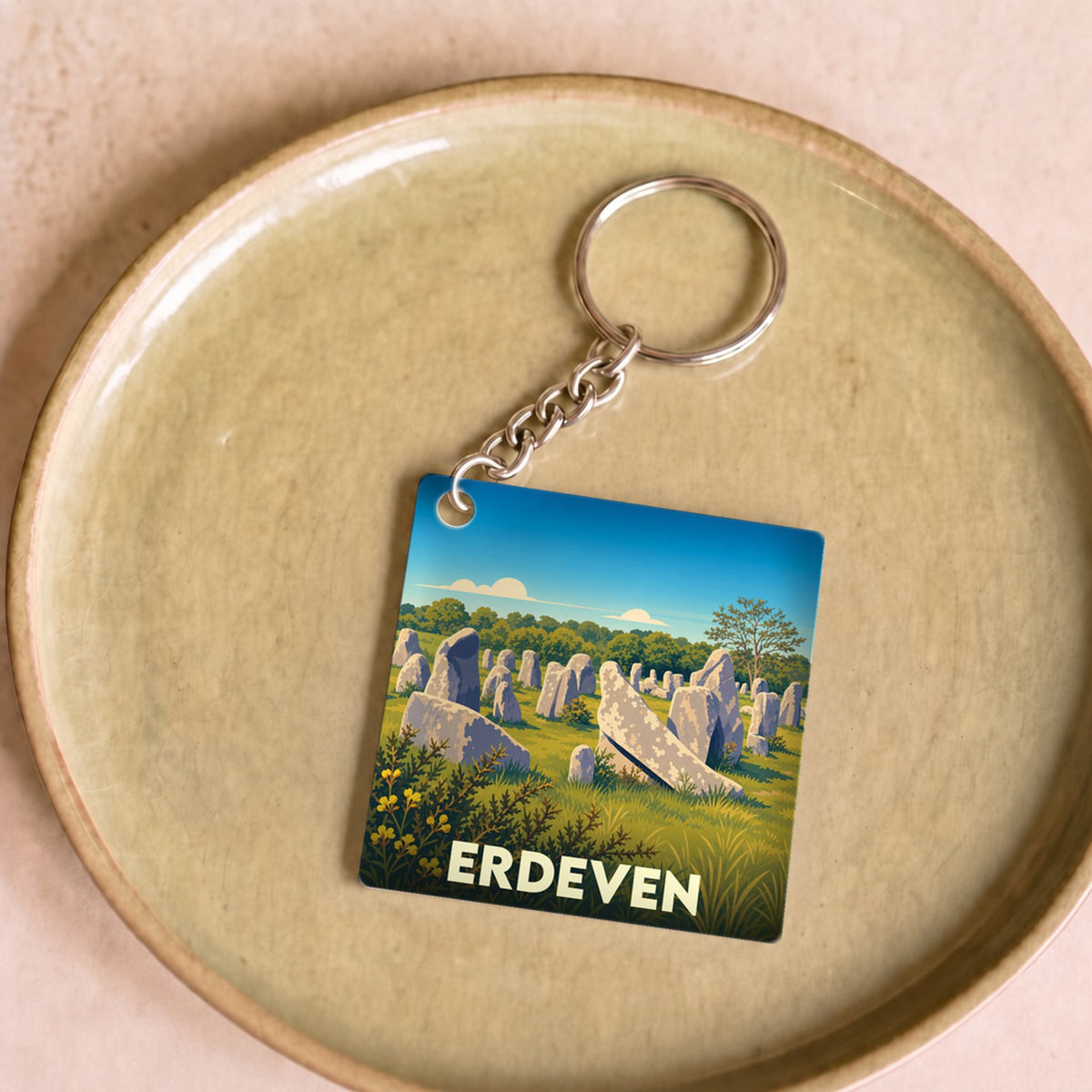 Porte-clés souvenir de la ville d'Erdeven illustrant ses célèbres alignements de menhirs dans un style graphique épuré.