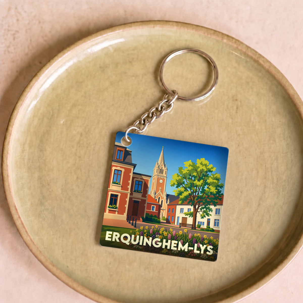 Porte-clés souvenir de la ville d'Erquinghem-Lys avec une illustration stylisée de son architecture et de ses jardins.