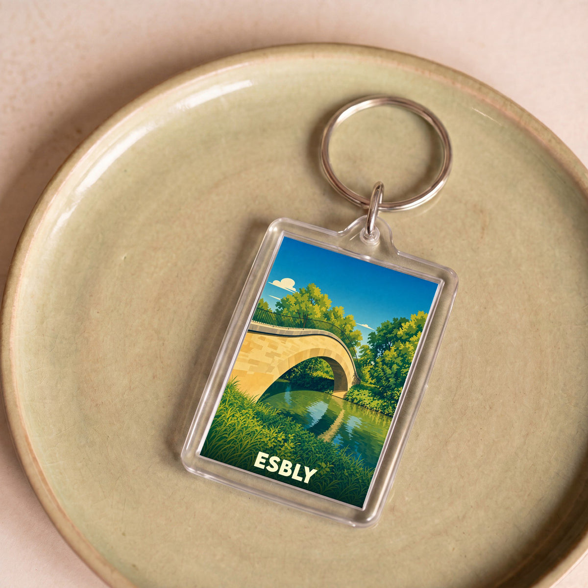 Porte-clés souvenir de la ville d'Esbly avec une illustration stylisée d'un pont en pierre.