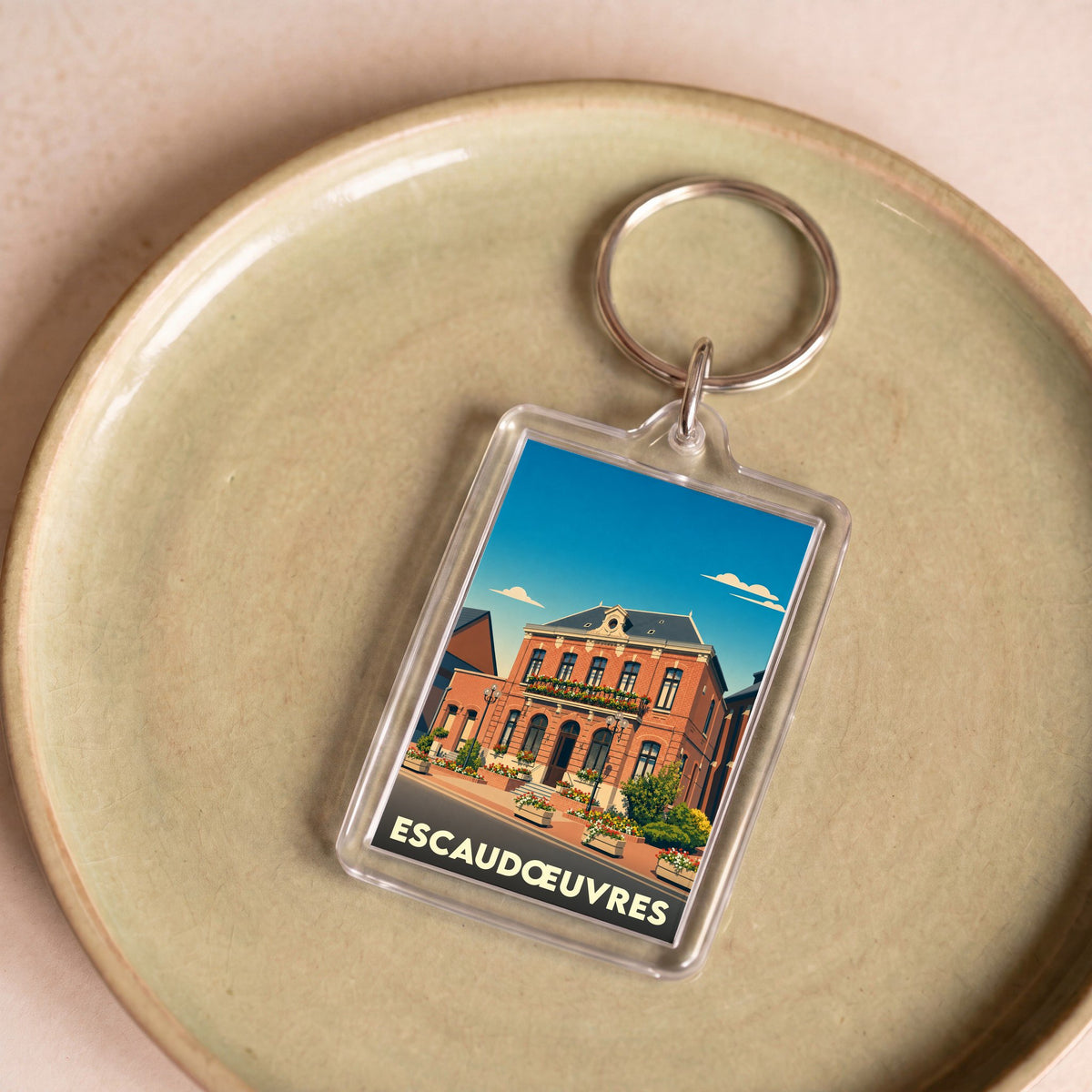 Porte-clés souvenir de la ville d'Escaudœuvres avec une illustration stylisée de son hôtel de ville.