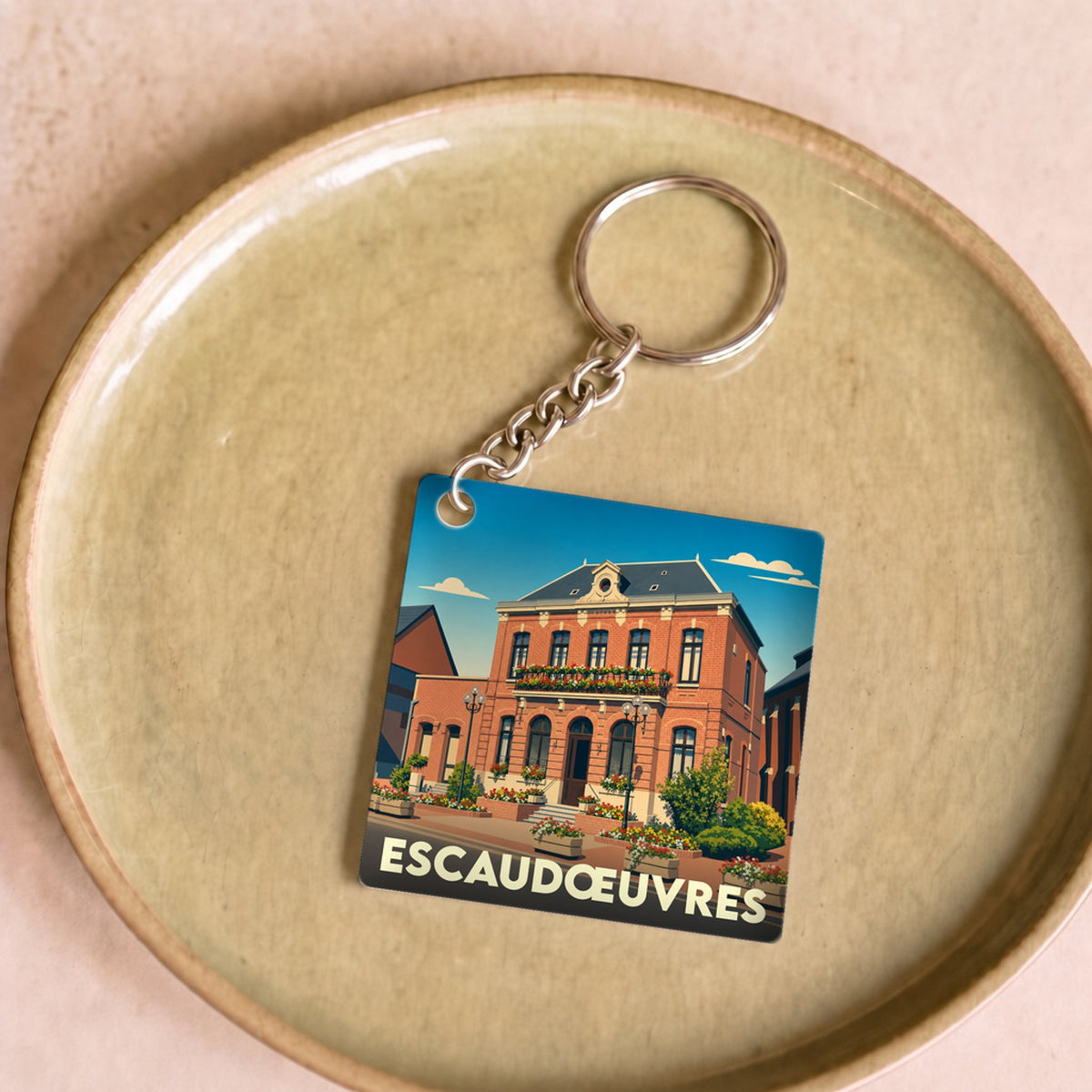Porte-clés souvenir de la ville d'Escaudœuvres avec une illustration stylisée de son hôtel de ville.