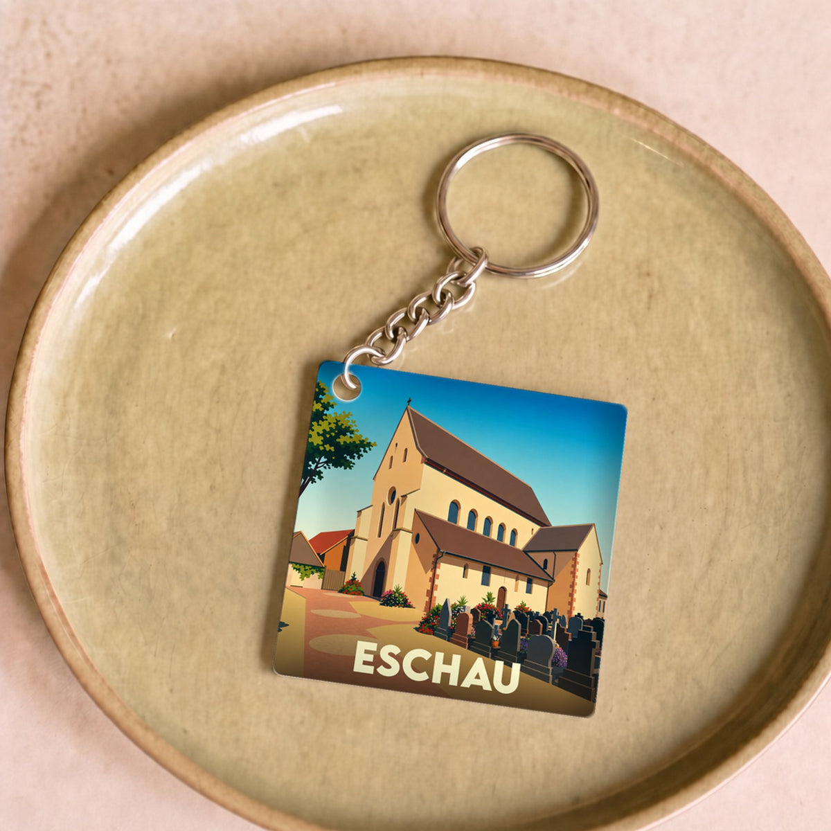 Porte-clés souvenir de la ville d'Eschau avec une illustration stylisée de son église abbatiale.