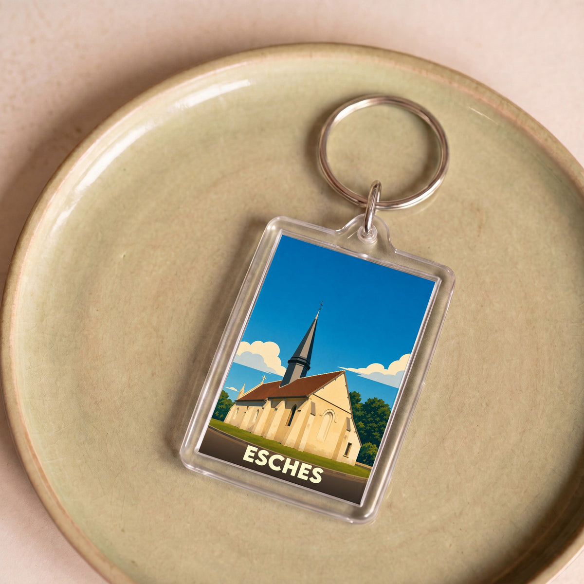 Porte-clés souvenir de la ville d'Esches avec une illustration stylisée de son église.