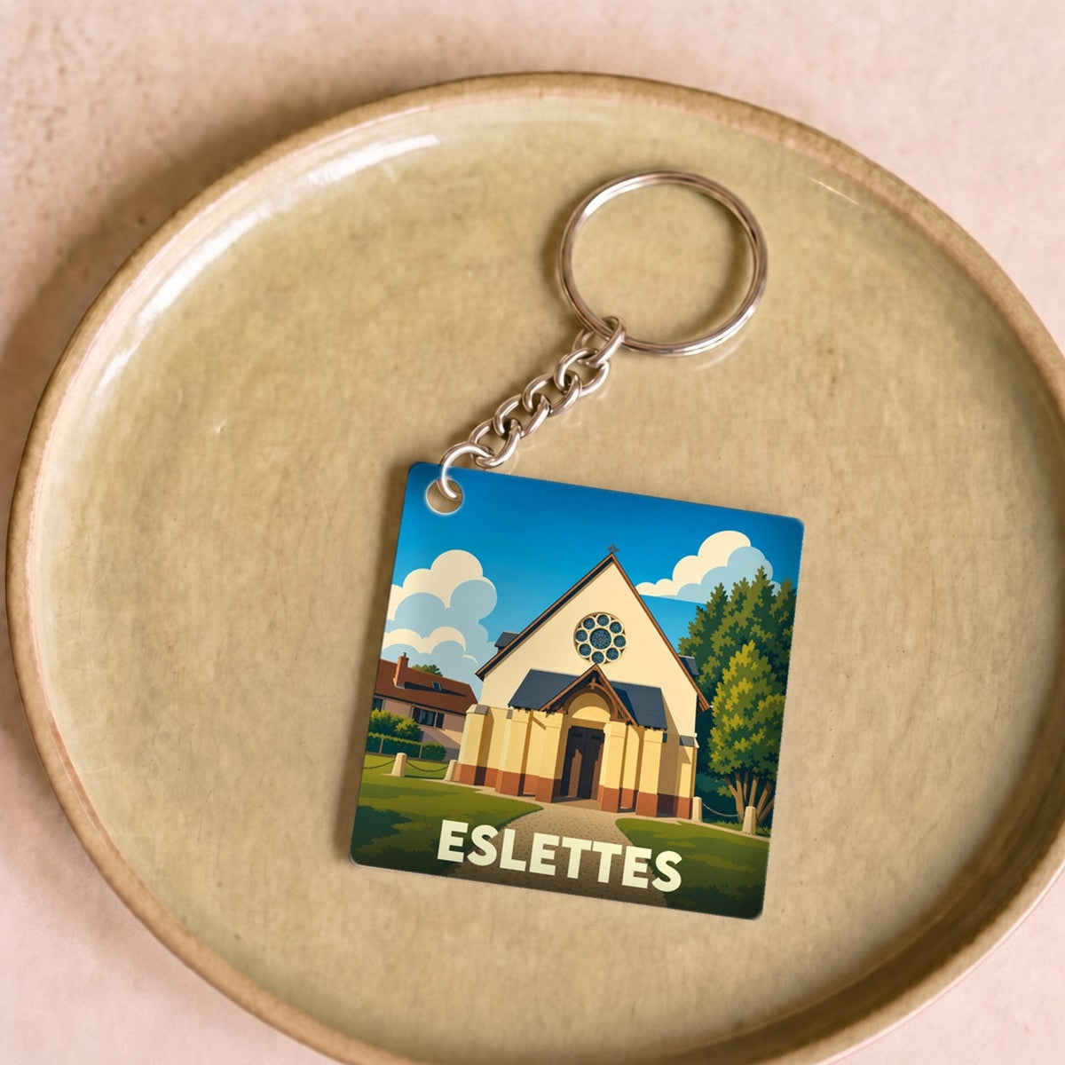 Porte-clés souvenir de la ville de Eslettes avec une illustration stylisée d'une église locale.