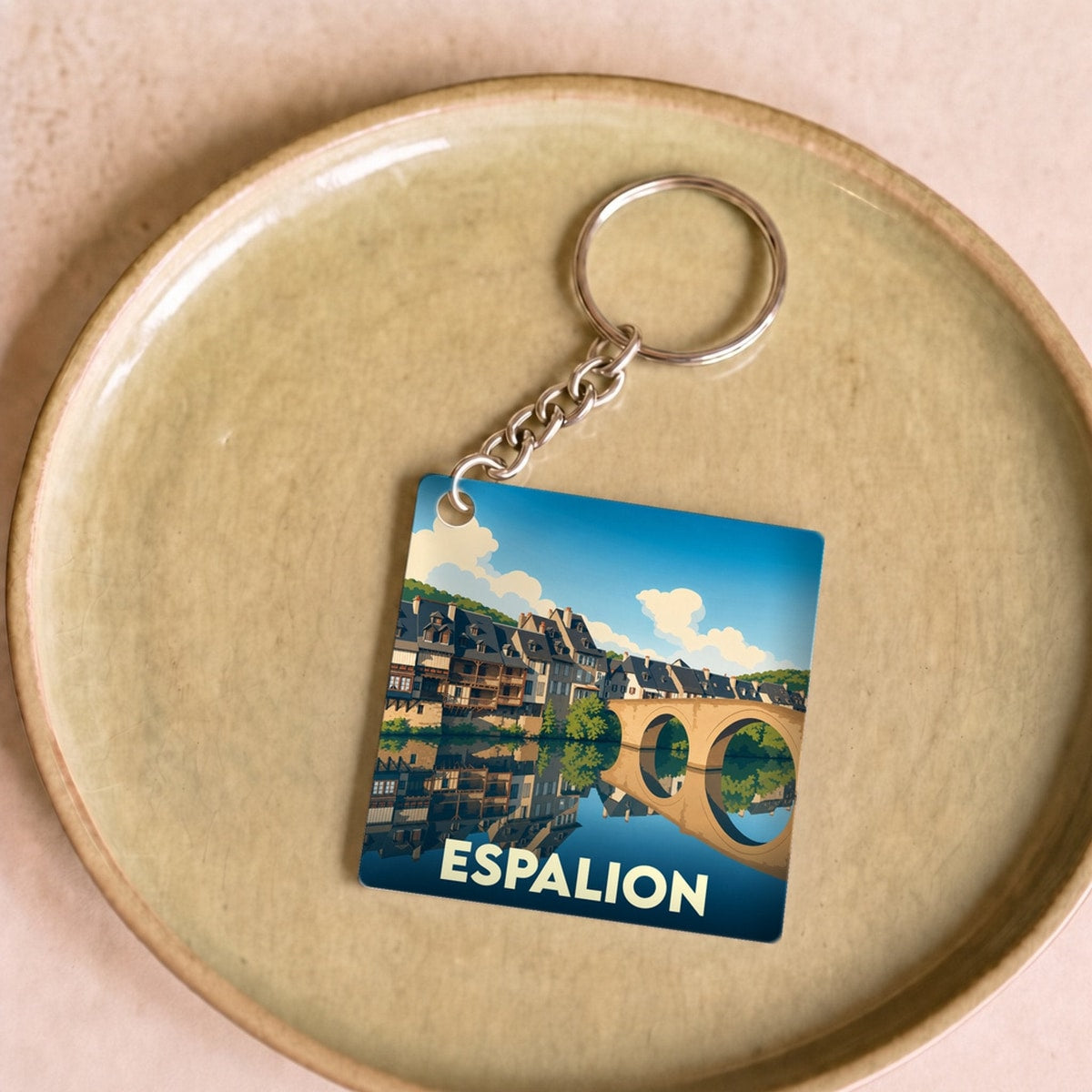 Porte-clés souvenir de la ville de Espalion avec une illustration stylisée.