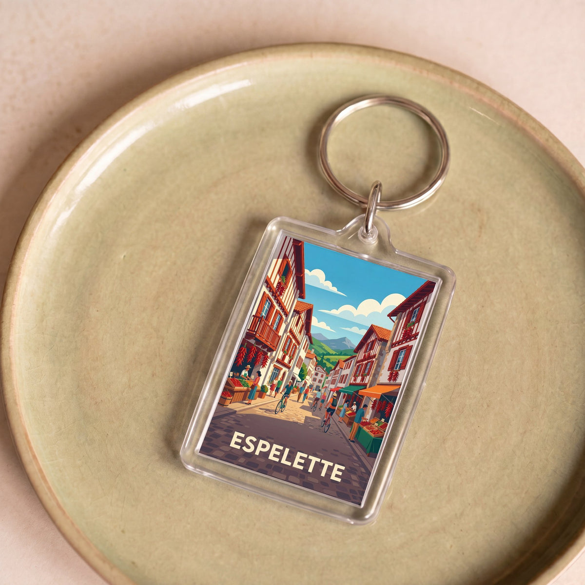 Porte-clés souvenir de la ville d'Espelette avec une illustration stylisée de ses rues typiques.