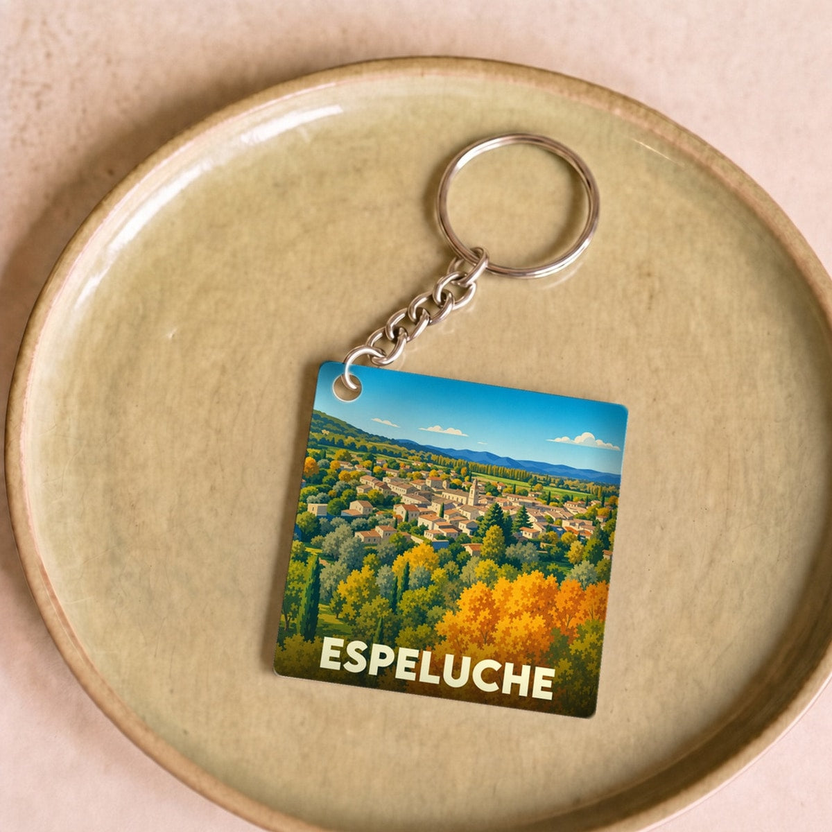 Porte-clés souvenir de la ville d'Espeluche avec une illustration stylisée de son paysage vallonné.