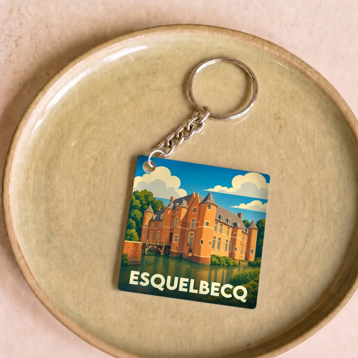 Porte-clés souvenir de la ville d'Esquelbecq avec une illustration stylisée de son château.