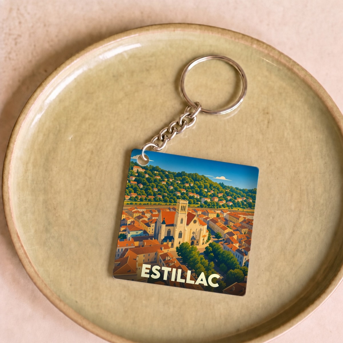 Porte-clés souvenir de la ville d'Estillac avec une illustration stylisée de son église et de ses collines.