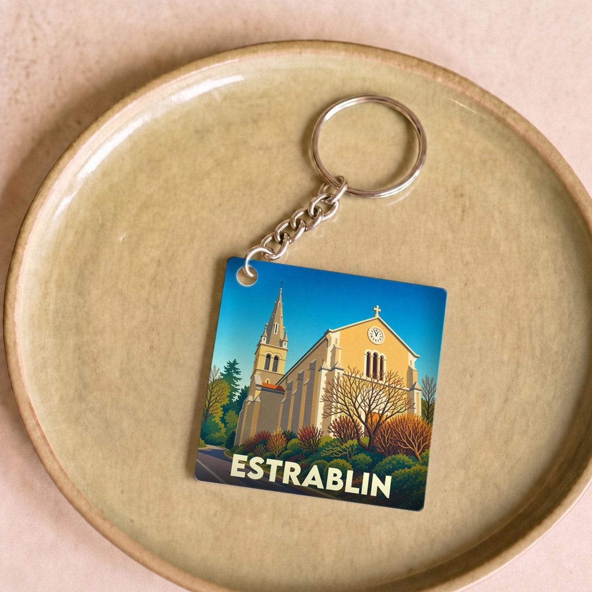Porte-clés souvenir de la ville de Estrablin avec une illustration stylisée de son église.