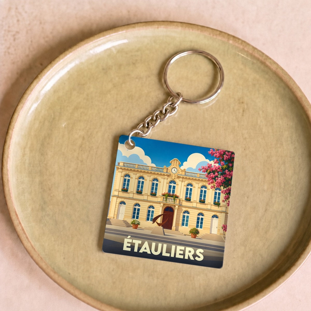 Porte-clés souvenir de la ville d'Étauliers avec une illustration stylisée de sa mairie.