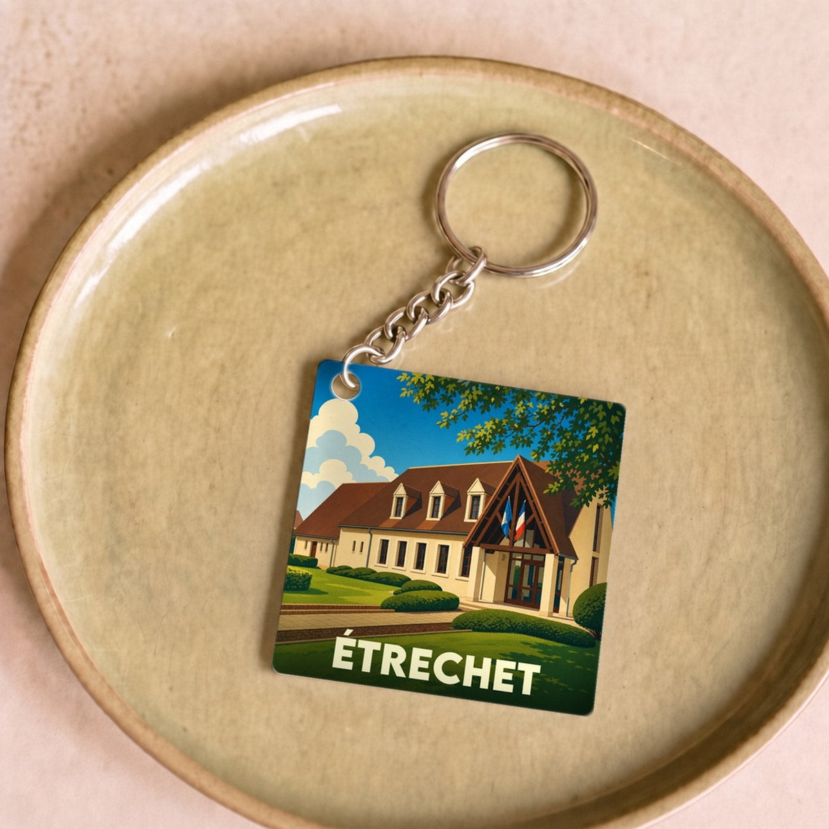 Porte-clés souvenir de la ville d'Étrechet avec une illustration stylisée de sa mairie.