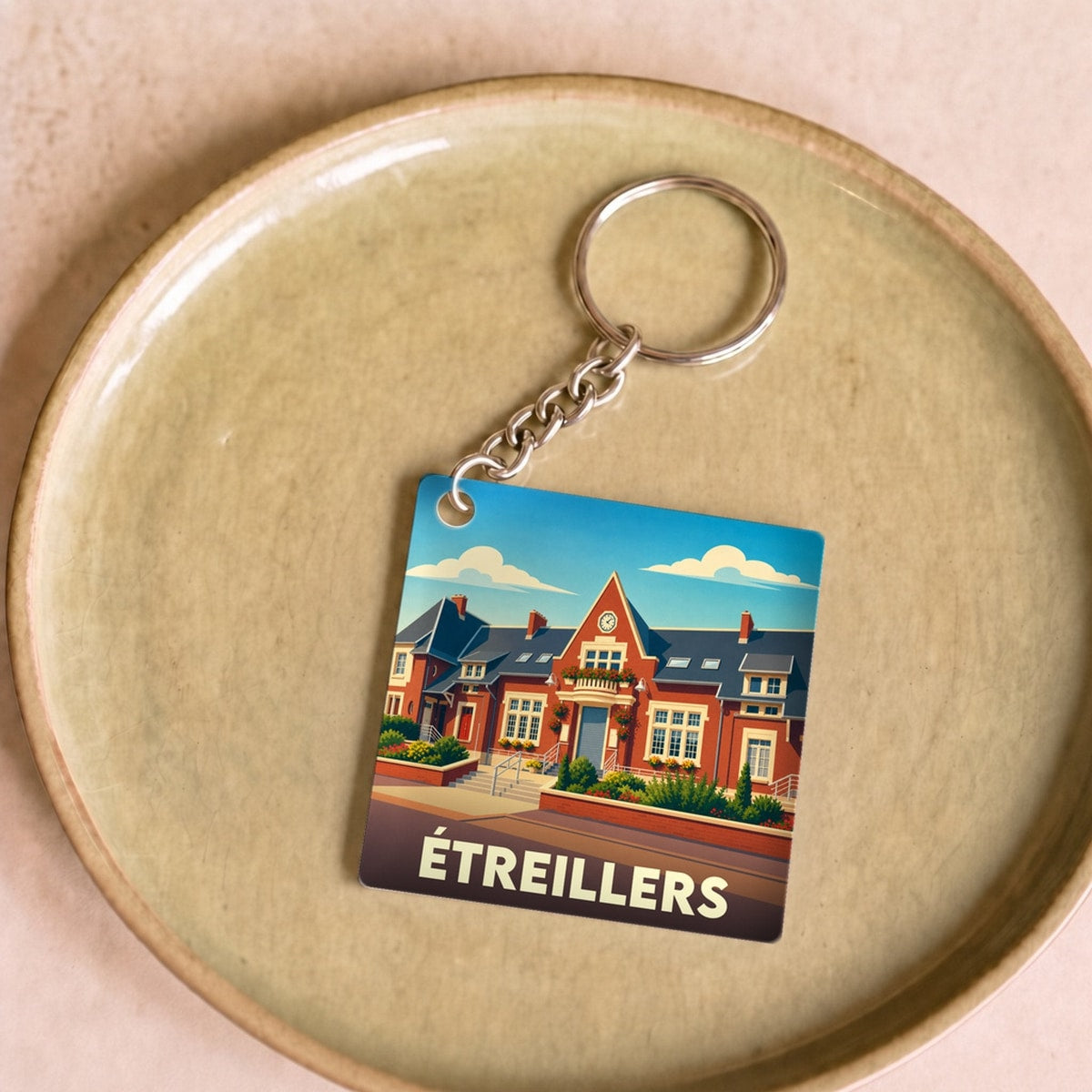 Porte-clés souvenir de la ville d'Étreillers avec une illustration stylisée de son architecture.