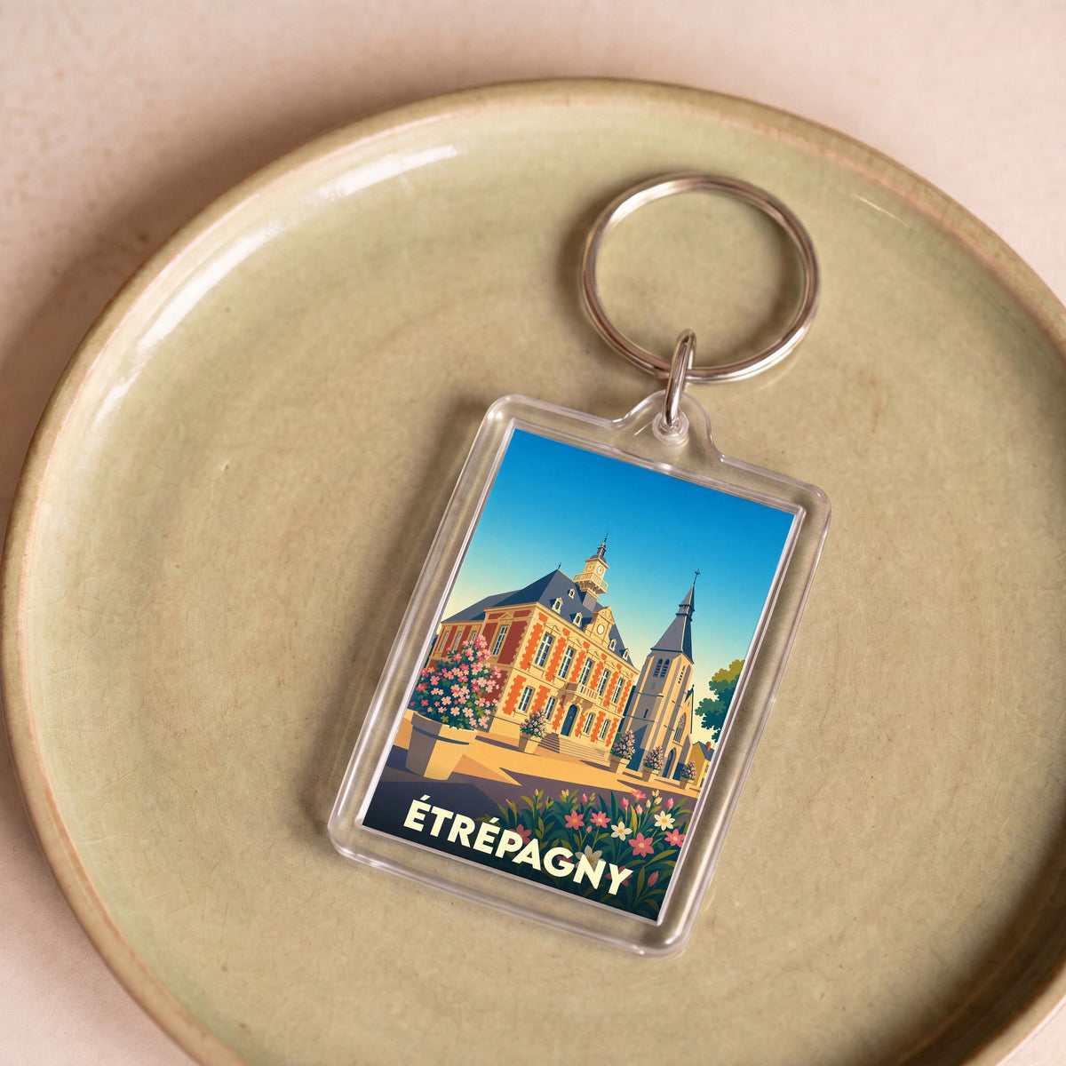 Porte-clés souvenir de la ville d'Étrépagny avec une illustration stylisée de son patrimoine.