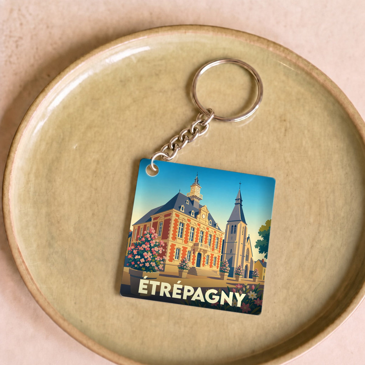 Porte-clés souvenir de la ville d'Étrépagny avec une illustration stylisée de son patrimoine.