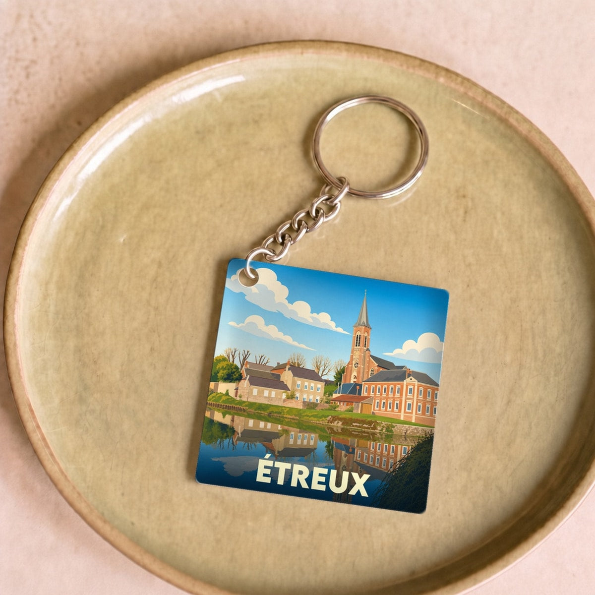 Porte-clés souvenir de la ville d'Étreux avec une illustration stylisée.
