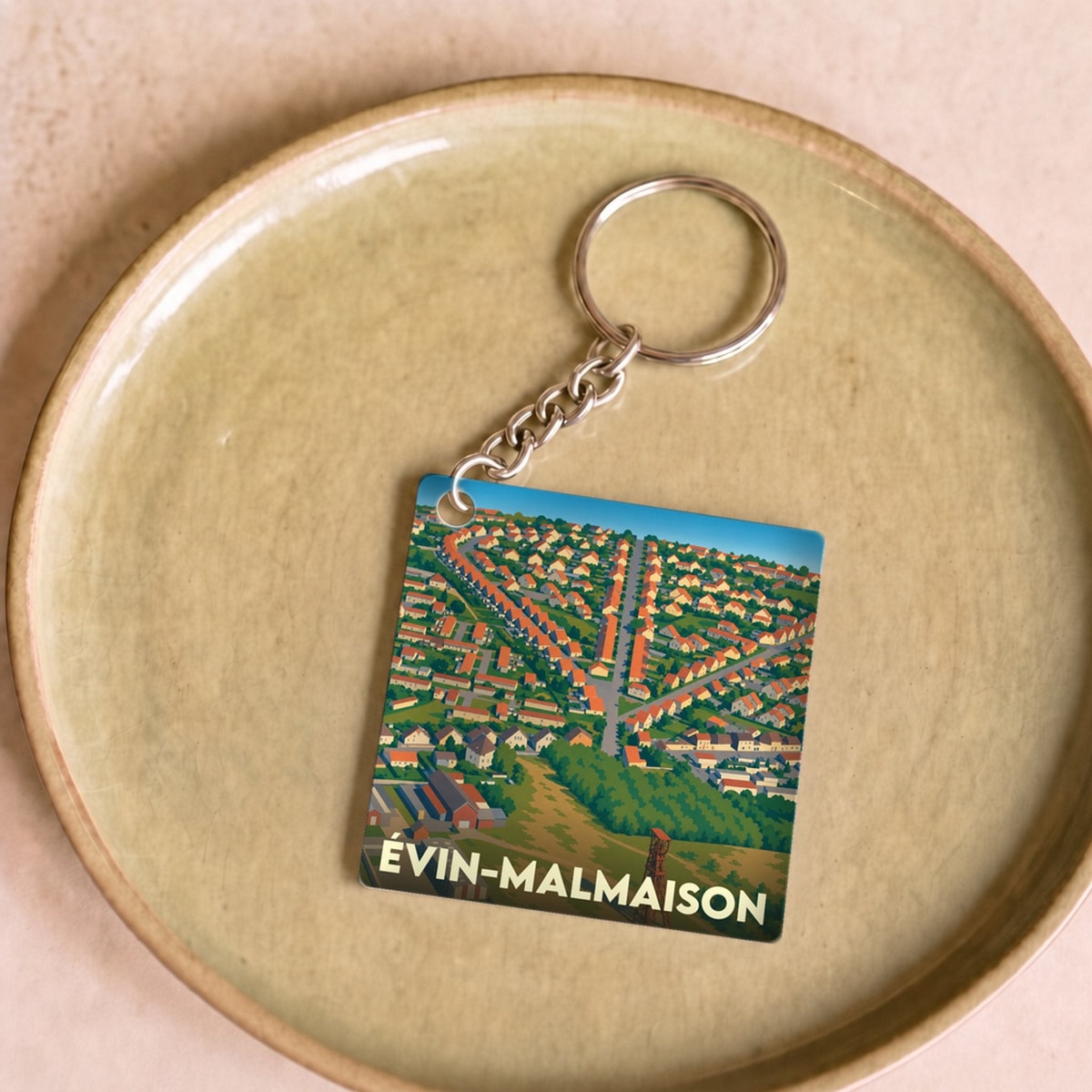 Porte-clés souvenir de la ville d'Évin-Malmaison avec une illustration stylisée vue du ciel.