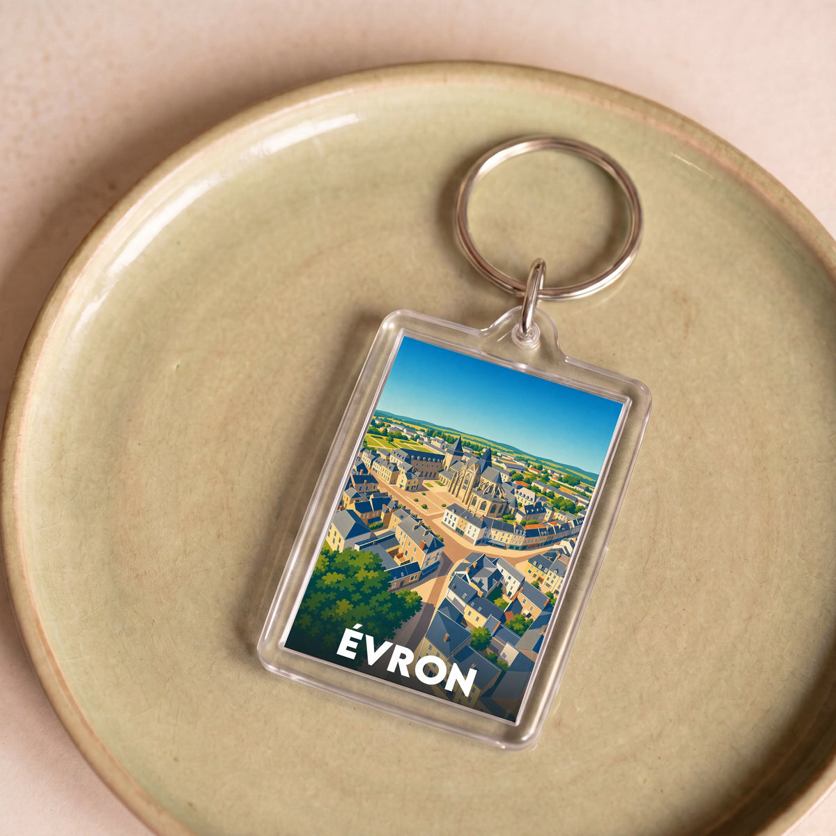 Porte-clés souvenir de la ville d'Évron avec une illustration stylisée vue du ciel.