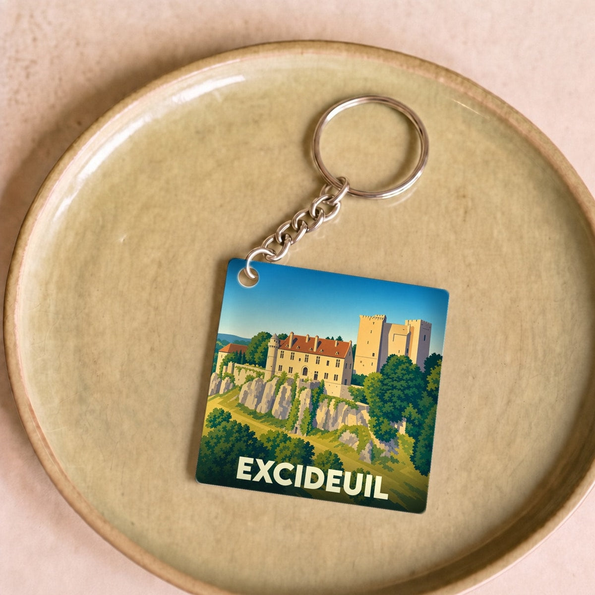 Porte-clés souvenir de la ville d'Excideuil avec une illustration stylisée de son château.