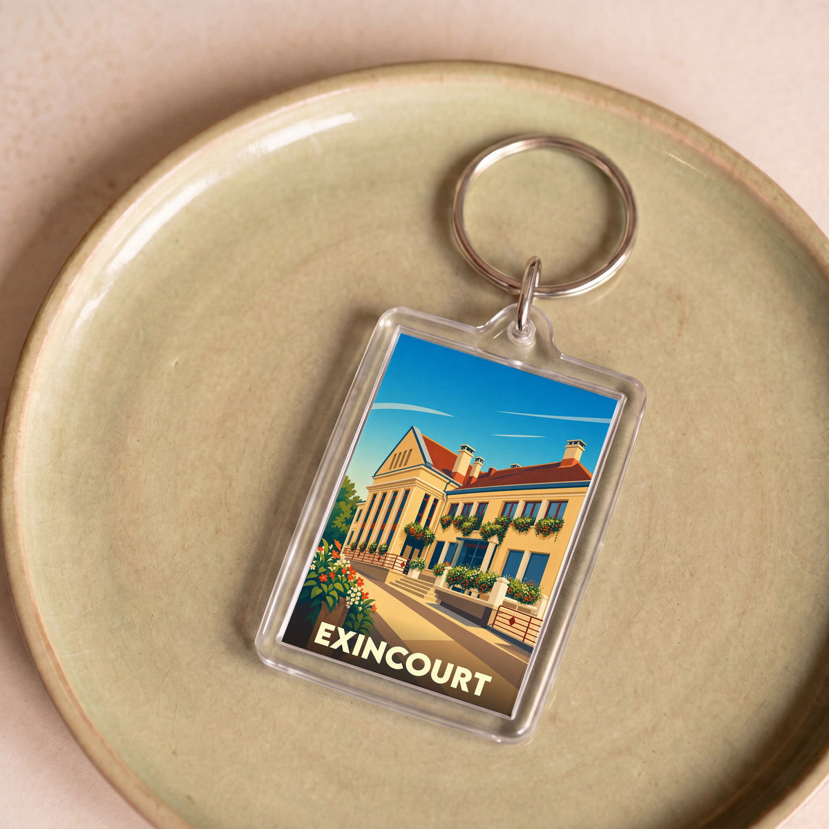Porte-clés souvenir de la ville d'Exincourt avec une illustration stylisée de son patrimoine architectural.