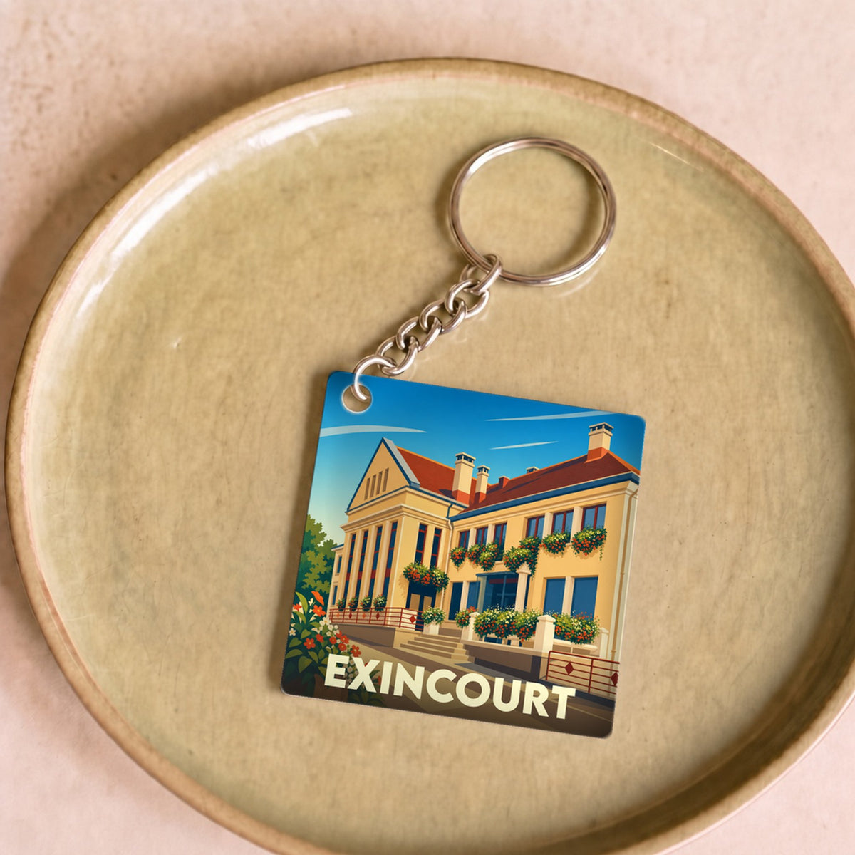 Porte-clés souvenir de la ville d'Exincourt avec une illustration stylisée de son patrimoine architectural.