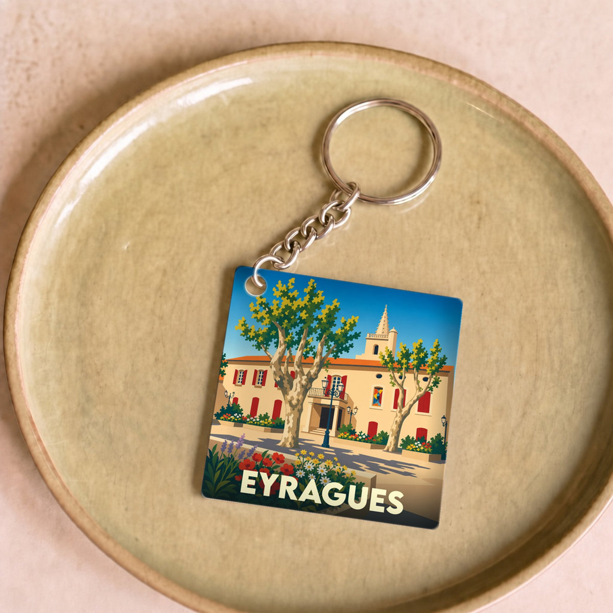 Porte-clés souvenir de la ville d'Eyragues avec une illustration stylisée.