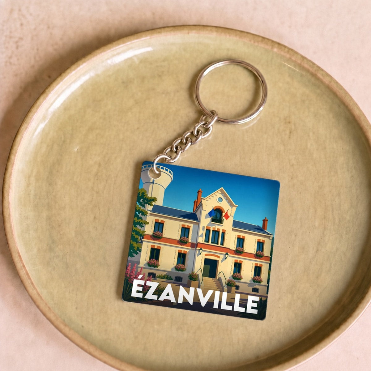 Porte-clés souvenir de la ville d'Ézanville avec une illustration stylisée de son hôtel de ville.