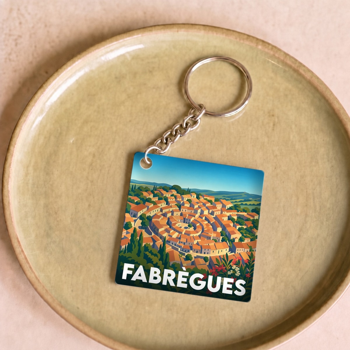 Porte-clés souvenir de la ville de Fabrègues avec une illustration stylisée.