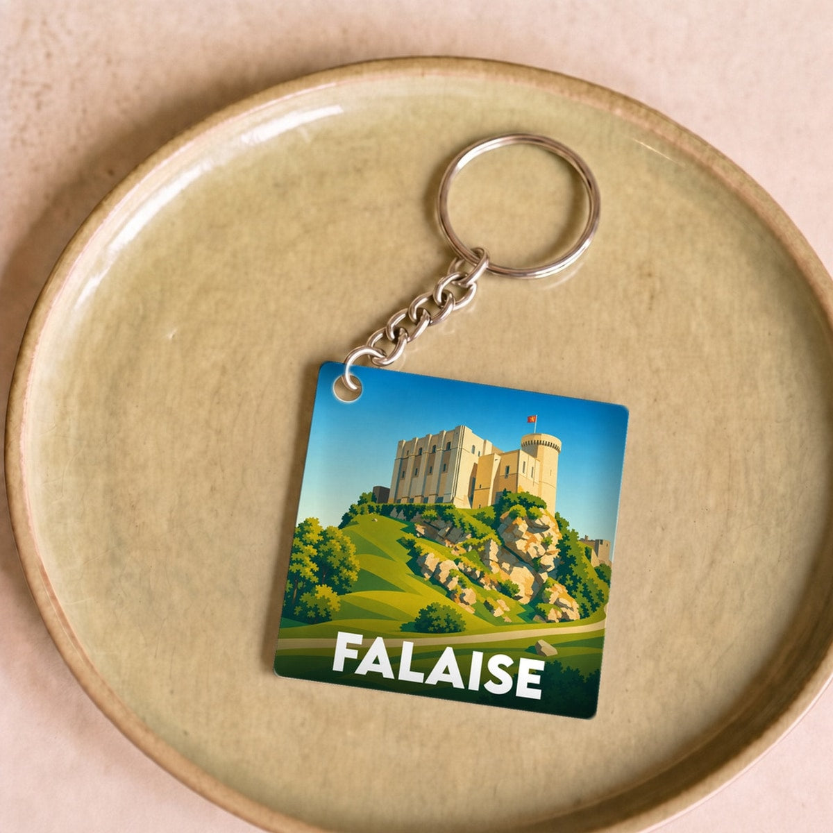 Porte-clés souvenir de la ville de Falaise avec une illustration stylisée de son château.