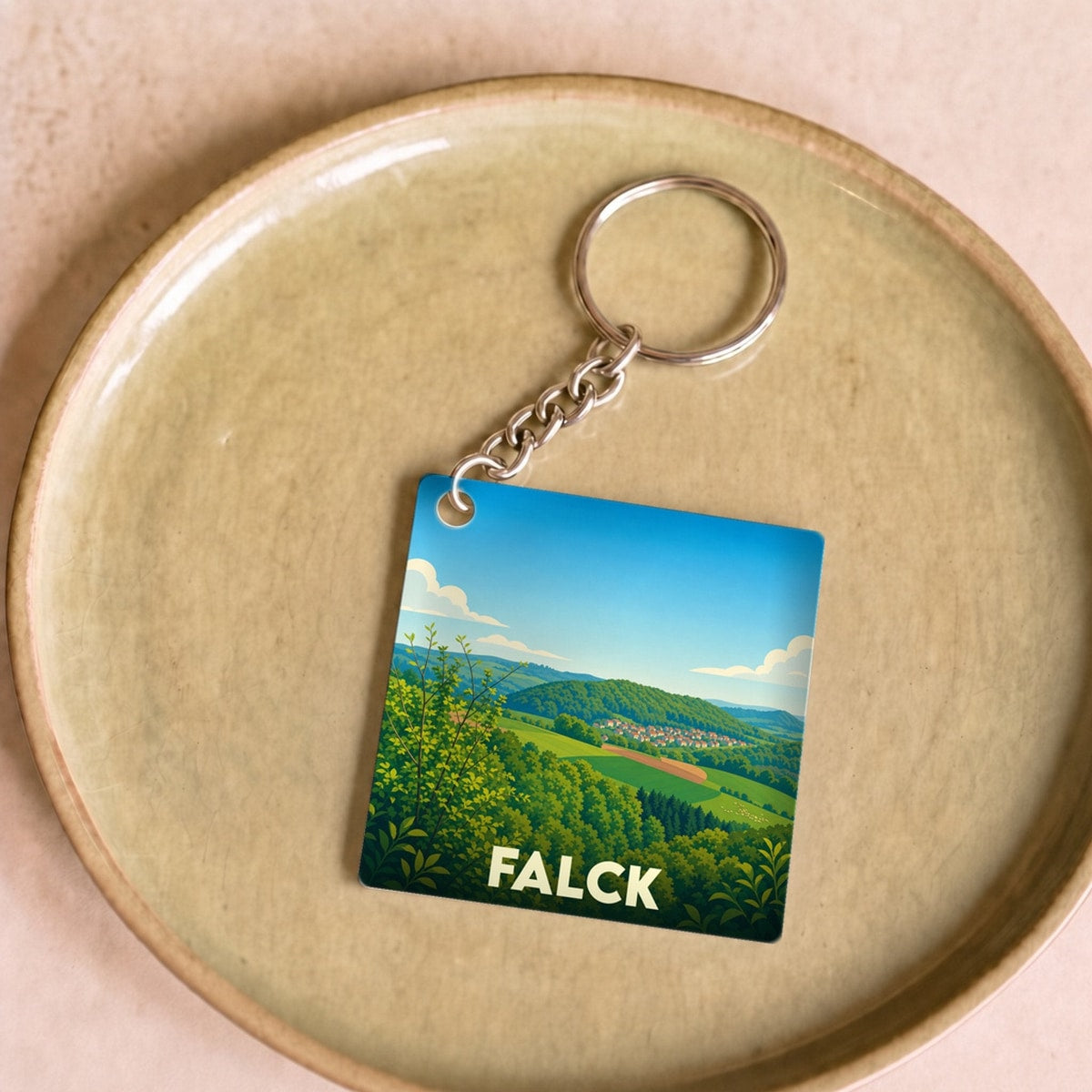Porte-clés souvenir de la ville de Falck avec une illustration paysagère stylisée.